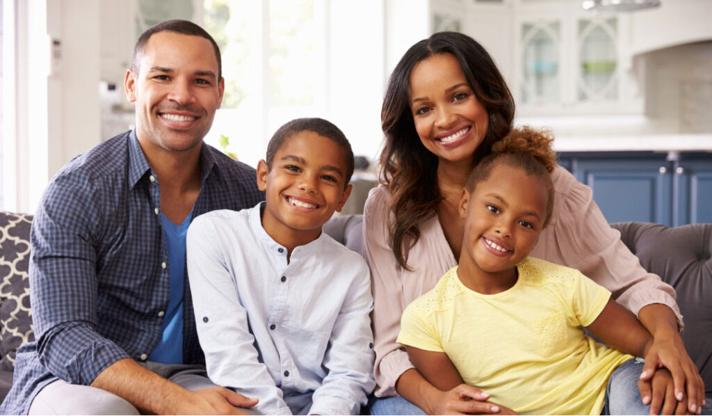 Father, Mother, son, daughter sitting on couch together