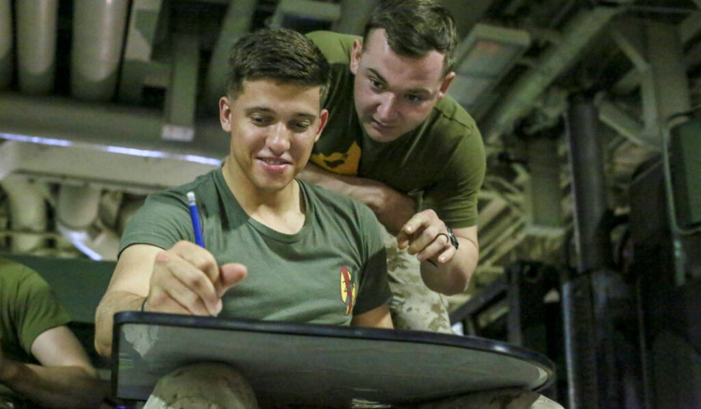 Two servicemembers working in a classroom