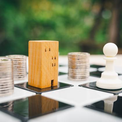 Chessboard with stacked coins and building as pieces