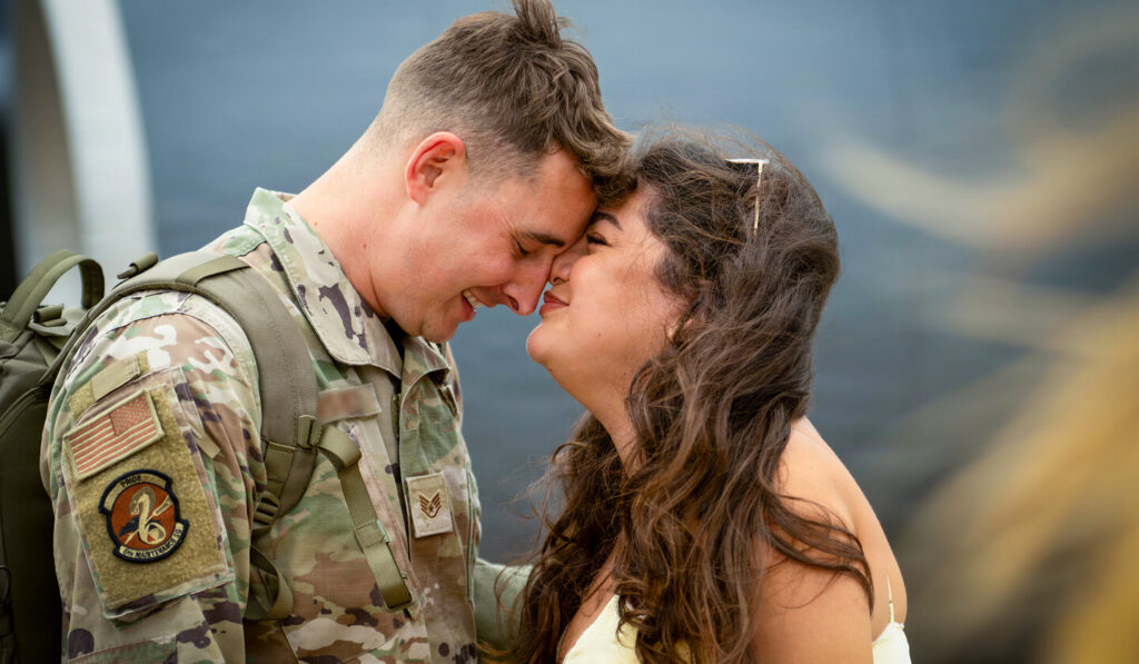 Service member embraces his partner during a reunion.